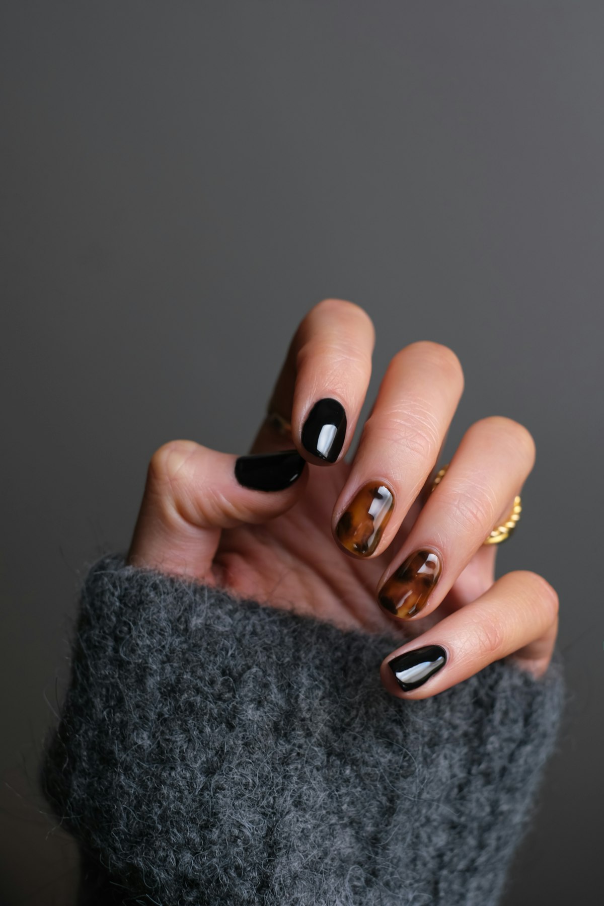 Glossy black and tortoiseshell manicure detail